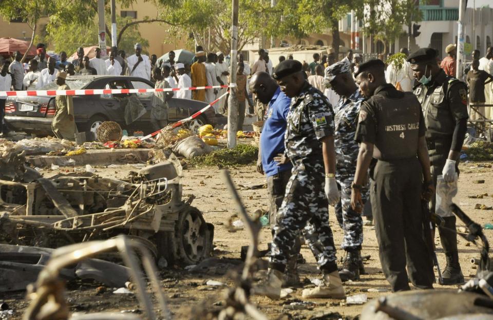 Bomb detection security personnel inspect the wreckage of a car believed to be used in the Kano Central Mosque bombing, November 28, 2014. Gunmen set off three bombs and opened fire on worshippers at the central mosque in north Nigeria's biggest city Kano, killing at least 35 people on Friday, witnesses and police said, in an attack that bore the hallmarks of Islamist Boko Haram militants. REUTERS/Stringer (NIGERIA - Tags: CIVIL UNREST)