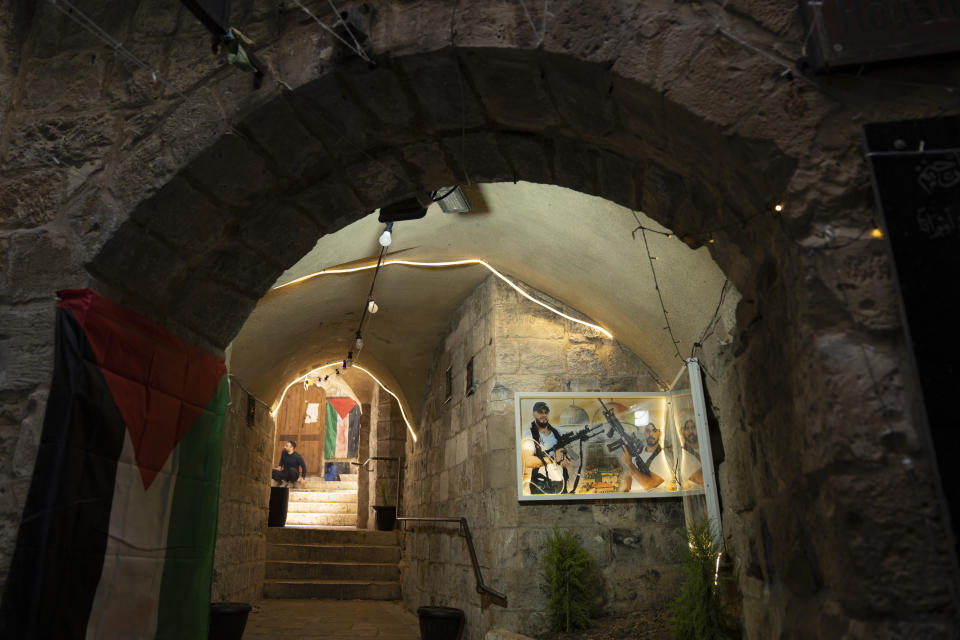 A poster with pictures of militants from the Lions' Den group who were killed by Israeli forces and Palestinian Flags decorates an alley at al-Yasmeena quarter of the West Bank old city of Nablus, Thursday, May 4, 2023. The killing of Zuhair al-Ghaleeth last month, the first slaying of a suspected Israeli intelligence collaborator in the West Bank in nearly two decades, has laid bare the weakness of the Palestinian Authority and the strains that a recent surge in violence with Israel is beginning to exert within Palestinian communities. (AP Photo/Nasser Nasser)