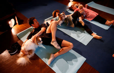 Pet owners attend a pet yoga session at the Pet Rainbow Festa, a pet funeral expo targeting an aging pet population, in Tokyo, Japan September 18, 2017. REUTERS/Kim Kyung-Hoon