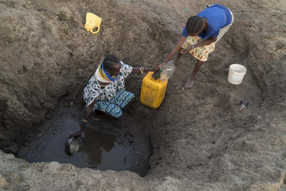 Dos mujeres recogen agua de un agujero en el lecho de un río seco en el condado de Turkana, Kenia, durante una sequía, el 6 de febrero de 2018. (Joao Silva/The New York Times)
