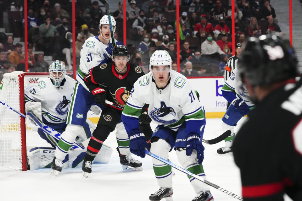 Vancouver Canucks goaltender Thatcher Demko (35) looks on as teammate Tyler Myers (57) battles with Ottawa Senators' Chris Tierney (71) as Nils Hoglander (21) anticipates a shot on net during the second period of an NHL hockey game, Wednesday, Dec.1, 2021 in Ottawa, Ontario. (Sean Kilpatrick/The Canadian Press via AP)