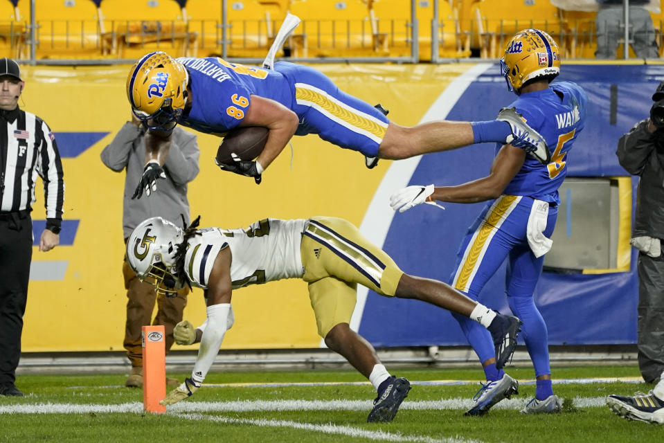 Pittsburgh tight end Gavin Bartholomew (86) dives over Georgia Tech defensive back LaMiles Brooks (20) into the end zone for a touchdown after catching a pass during the first half of an NCAA college football game, Saturday, Oct. 1, 2022, in Pittsburgh. (AP Photo/Keith Srakocic)