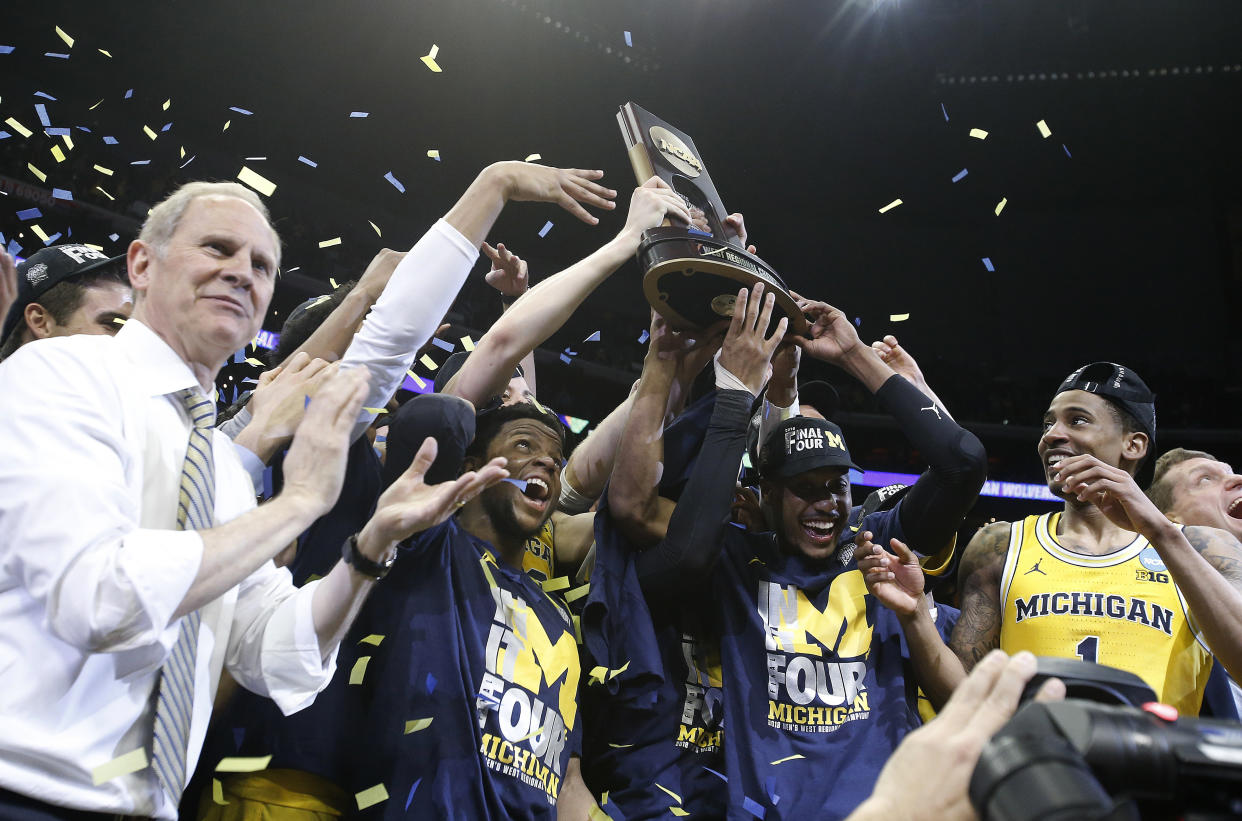 Michigan coach John Beilein, left, and players celebrate after the team’s 58-54 win over Florida State in an NCAA men’s college basketball tournament regional final Saturday, March 24, 2018, in Los Angeles. (AP Photo/Jae Hong)