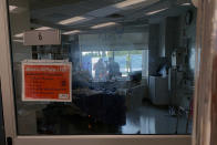 Family members gather outside Daryl Barker's window at Lake Regional Hospital in Osage Beach, Mo., on Monday, July 26, 2021. Daryl was one of 10 family members to become infected with COVID-19 but the 31-year-old's case was by far the worst. None had chosen to be vaccinated, a trend being seen as the delta variant spreads across Missouri's younger population. (AP Photo/Sarah Blake Morgan)