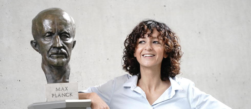 Emmanuelle Charpentier appuyée contre un buste de Max Planck.
