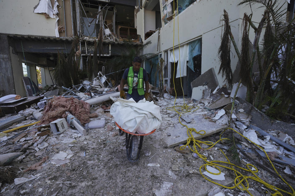 A man uses a wheelbarrow to clear debris in the aftermath of Hurricane Otis, in the Diamonds subdivision of Acapulco, Mexico, Thursday, Nov. 9, 2023. Nearly three weeks after the Category 5 hurricane devastated this Pacific port, leaving at least 48 people dead and the city’s infrastructure in tatters, the cleanup continues. (AP Photo/Marco Ugarte)