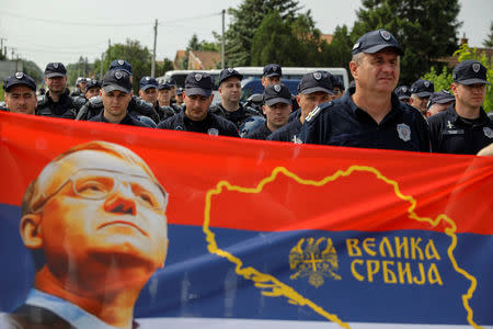 Supporters of Serbian Radical Party leader Vojislav Seselj hold banners in front of police officers during a protest in the village of Jarak, near Hrtkovci, Serbia, May 6, 2018. REUTERS/Marko Djurica