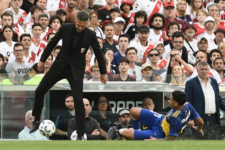 Martín Demichelis controla una pelota que se fue por un costado, ante una barrida de Ezequiel Fernández; el entrenador de River se fue 