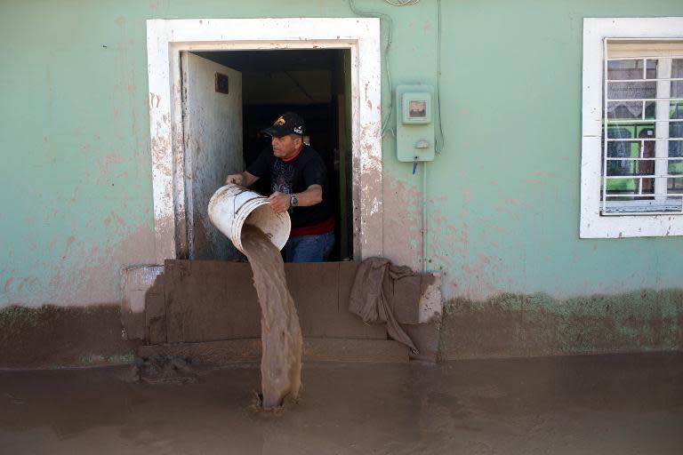 A man empties his home flooded by heavy rainfall, in Copiapo, Chile on March 26, 2015