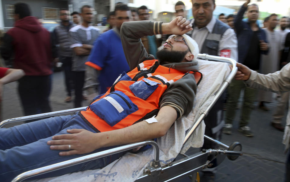 Medics move their wounded colleague, who was shot by Israeli troops during a protest at the Gaza Strip's border with Israel, into the treatment room of Shifa hospital in Gaza City, Friday, May 3, 2019. Three Palestinians, including two militants, were killed by Israeli fire Friday after gunshots from the Gaza Strip wounded two Israeli soldiers, officials said, in a new flare-up that shattered a month-long easing of hostilities that was mediated by Egypt. (AP Photo/Adel Hana)