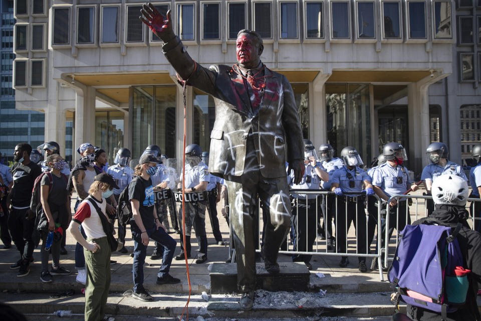 Police stand near the former mayor's vandalized statue on May 30 during protests over the death of George Floyd. (Photo: ASSOCIATED PRESS)