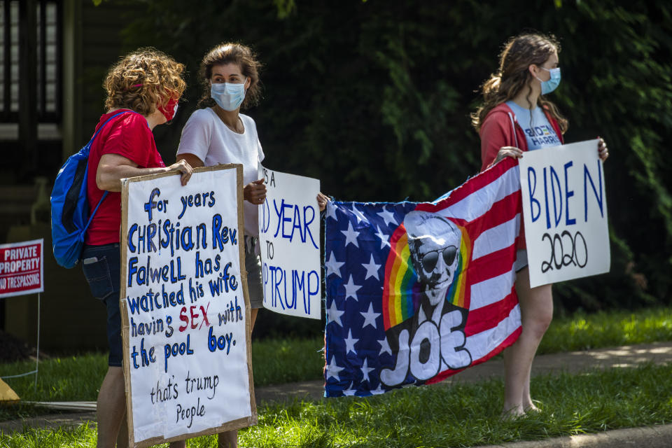 Protesters hold banners as they wait for the motorcade of President Trump outside the Trump National Golf Club in Sterling,, Va., Sunday, Aug. 30, 2020. (AP Photo/Manuel Balce Ceneta)