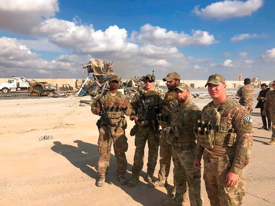 FILE - In this Jan. 13, 2020 file photo, U.S. soldiers stand at the site of an Iranian bombing at Ain al-Asad air base in Anbar, Iraq. On Tuesday, March 23, 2021, Iraqi officials said Iraq has sent a formal request to President Joe Biden's administration for a date to resume strategic talks on bilateral relations and the withdrawal of remaining U.S. combat forces. The talks, which began in June under the Trump administration, would be the first under Biden, who assumed office in January. (AP Photo/Qassim Abdul-Zahra, File)