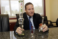 In this Wednesday, Jan. 4, 2017 photo, attorney Jamie Sasson holds counterfeit Roor bongs at his office in Deerfield Beach, Fla. High-end German glass water pipe maker Roor and its American licensee are filing lawsuits against smoke shops and mom-and-pop convenience stores in Florida, California and New York alleging that they are selling Roor counterfeits, violating its trademark. (AP Photo/Lynne Sladky)