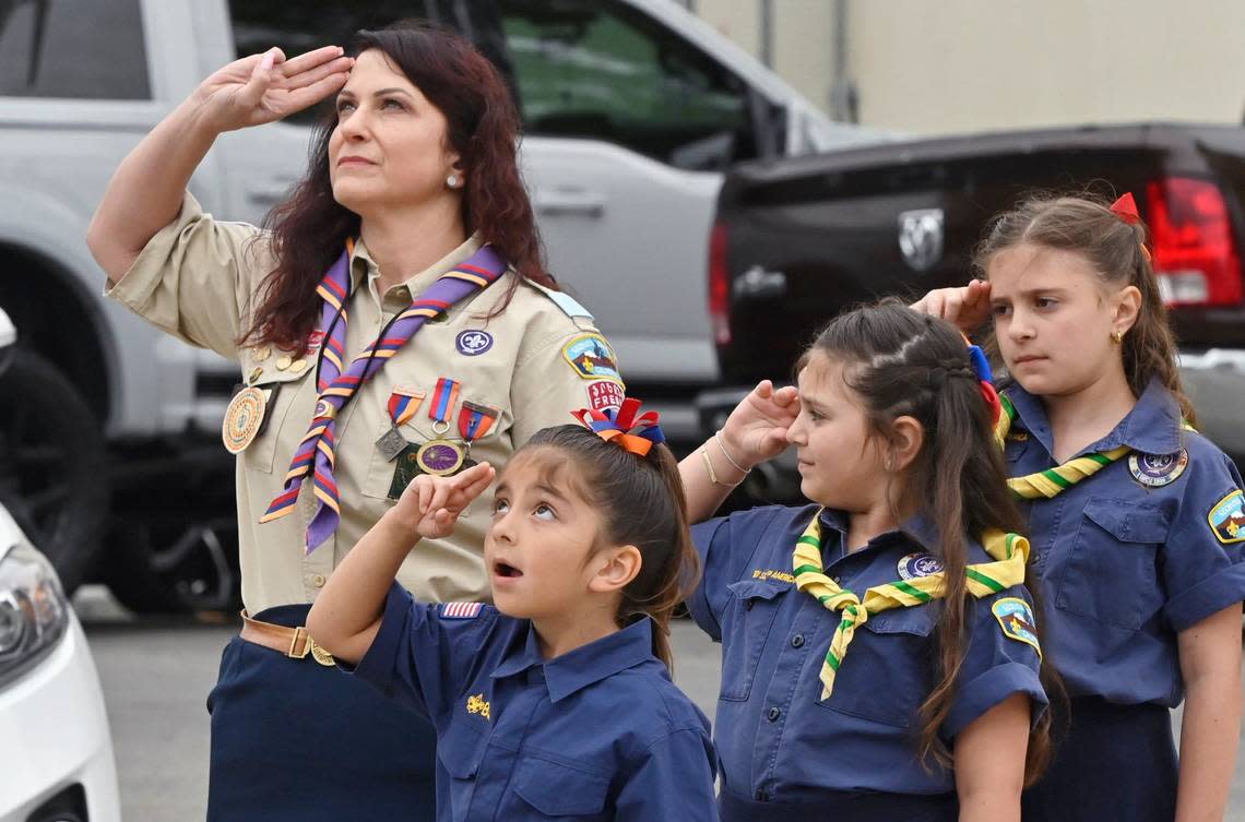 Scouts salute as the Armenian flag is raised during a ceremony outside Fresno City Hall in remembrance of the 1915 Armenian genocide, Wednesday, April 24, 2024 in Fresno.