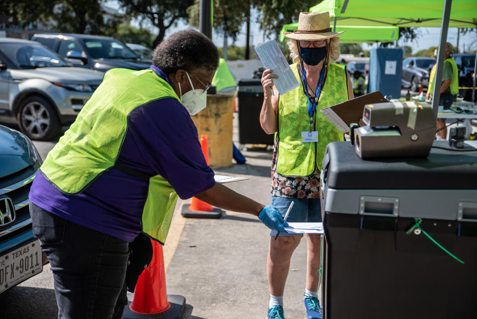 Workers drop voters ballots into a secure box at a ballot drop off location on October 13, 2020 in Austin, Texas. (Sergio Flores/Getty Images)