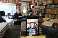 A smartphone broadcasts on Facebook Live pianist, composer and arranger Mike Greensill joining vocalist Kellie Fuller for a "virtual cocktail party piano bar" Thursday, March 19, 2020, in St. Helena, Calif. All public music venues in the Napa Valley have been closed due to the coronavirus restrictions and the pair held the virtual show as a way to keep performing. (AP Photo/Eric Risberg)