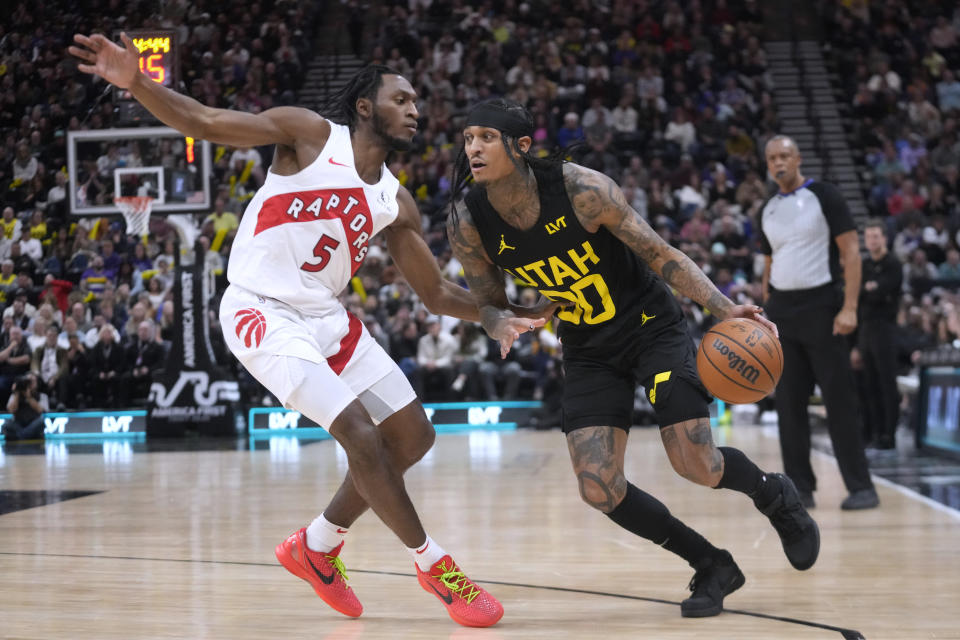 Utah Jazz guard Jordan Clarkson (00) drives as Toronto Raptors guard Immanuel Quickley (5) defends during the first half of an NBA basketball game Friday, Jan. 12, 2024, in Salt Lake City. (AP Photo/Rick Bowmer)