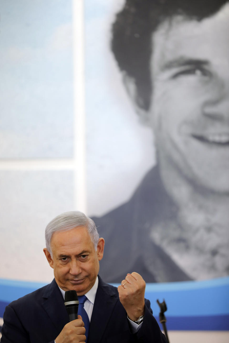 Israeli Prime Minister Benjamin Netanyahu speaks to students as he stands in front of a banner depicting his late brother Yonatan Netanyahu, during a dedication ceremony at Ort Samaria Ulpana school in the settlement of Elkana Sunday, Sept. 1, 2019. Netanyahu is reaffirming his pledge to impose Israeli sovereignty on West Bank settlements. (Amir Cohen/Pool Photo via AP)