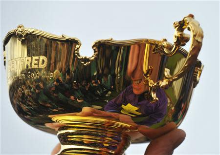 Jockey Davy Russell poses with the Gold Cup trophy after his mount Lord Windermere won the Gold Cup at the Cheltenham Festival horse racing meet in Gloucestershire, western England March 14, 2014. REUTERS/Toby Melville