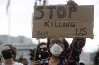 Wendy Meyer holds up a sign at a protest over the Memorial Day death of George Floyd, a handcuffed black man in police custody in Minneapolis, in San Francisco, Saturday, May 30, 2020. (AP Photo/Jeff Chiu)