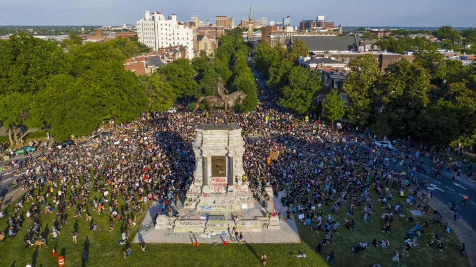 FILE - This Tuesday, June 2, 2020 file photo shows a large group of protesters gather around the statue of Confederate General Robert E. Lee on Monument Avenue near downtown in Richmond, Va. Virginia Gov. Ralph Northam is expected to announce plans Thursday for the removal of an iconic statue of Confederate Gen. Robert E. Lee from Richmond's prominent Monument Avenue. (AP Photo/Steve Helber, File)