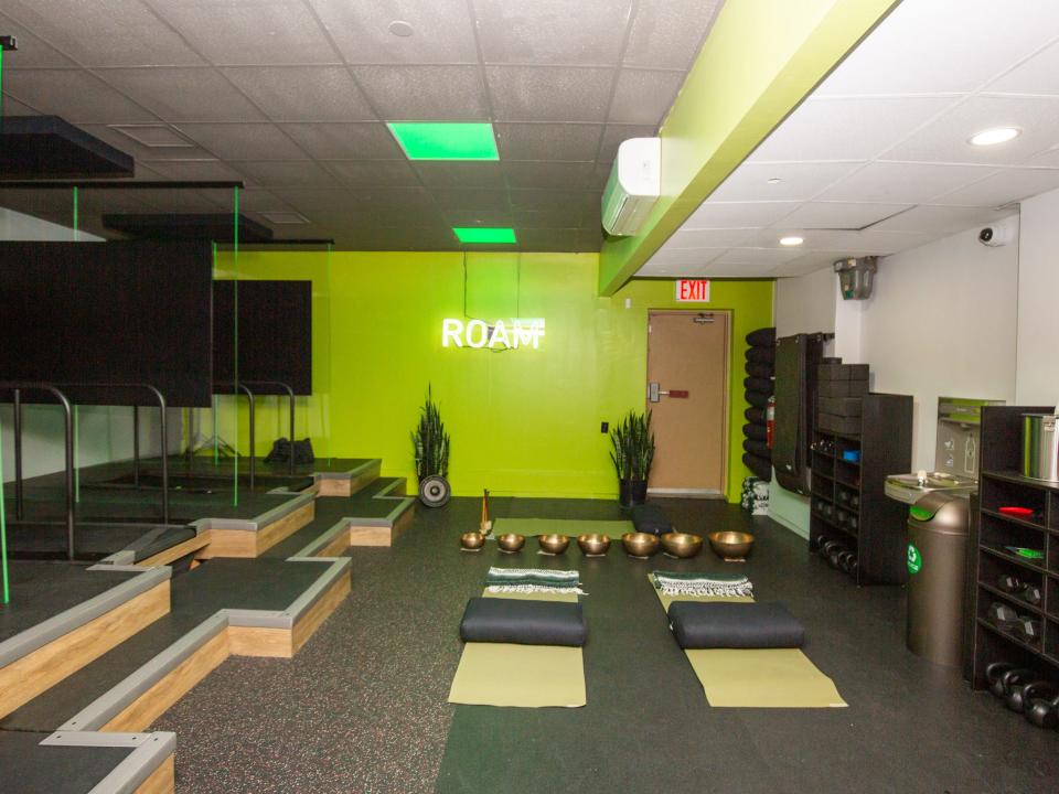 Inside Roam149's gym with yoga mats, treadmills, weights.