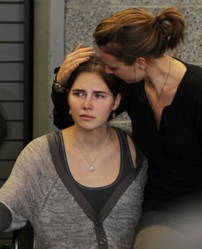 Amanda Knox (L) is comforted by her sister, Deanna Knox, during a news conference shortly after her arrival at Seattle-Tacoma International Airport. A tearful Knox paid tribute to her supporters as she arrived home, after being acquitted of murder and sexual assault and ending a four-year ordeal behind bars in Italy