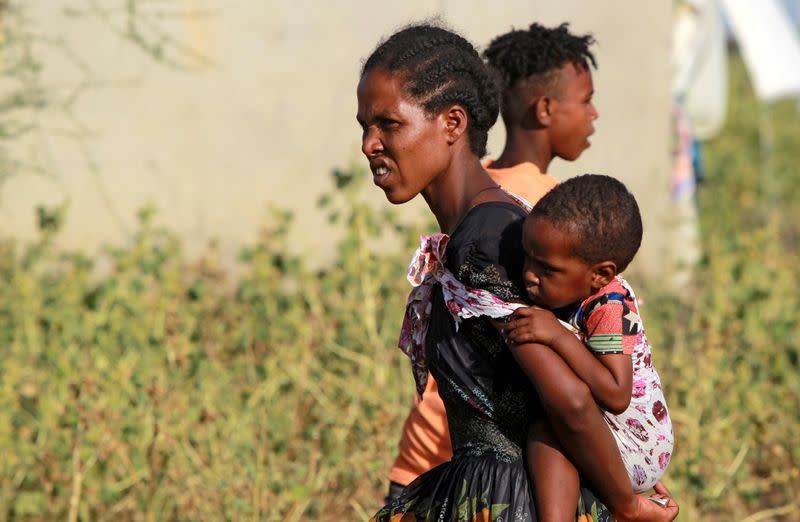 Ethiopian woman who fled war in Tigray region, carries a child at the Fashaga camp on the Sudan-Ethiopia border in Al-Qadarif state