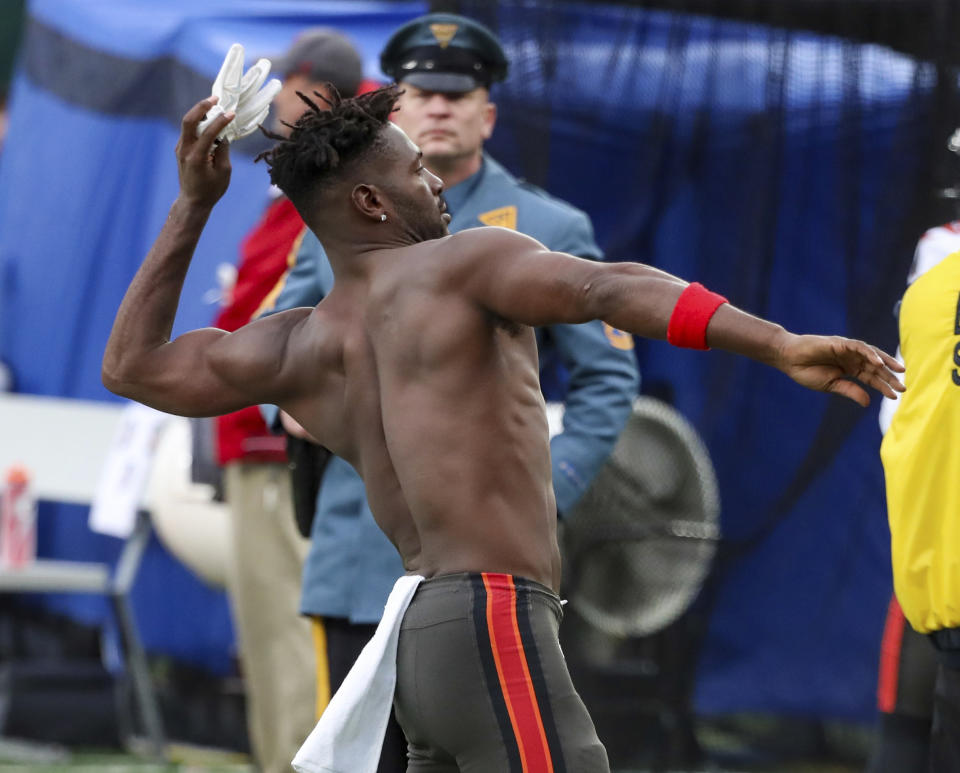 A N.J. State Police trooper, background, watches as Tampa Bay Buccaneers wide receiver Antonio Brown (81) throws his gloves into the stands while his team's offense is on the field against the New York Jets during the third quarter of an NFL football game Sunday, Jan. 2, 2022, in East Rutherford, N.J. (Andrew Mills/NJ Advance Media via AP)