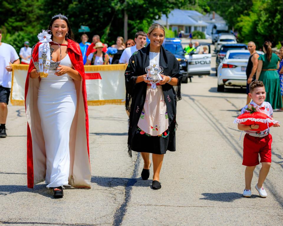 Representing Queen Isabela, Jessica Varao, Queen, left, Allison Varao, Crown Member, and Matteo Bicho, Crown Child carry the Crowns from St. Mary's for the 2022 Holy Ghost Festa in North Plymouth.