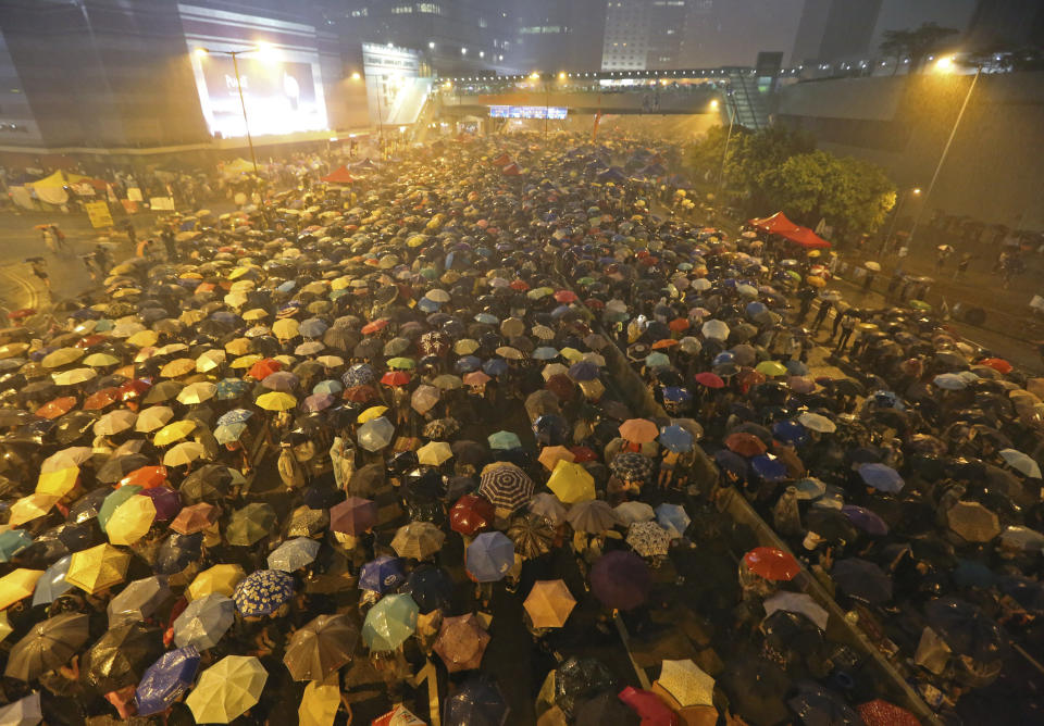 Pro-democracy protesters hold umbrellas under heavy rain in a main street near the government headquarters in Hong Kong late Tuesday, Sept. 30, 2014.  (AP Photo)