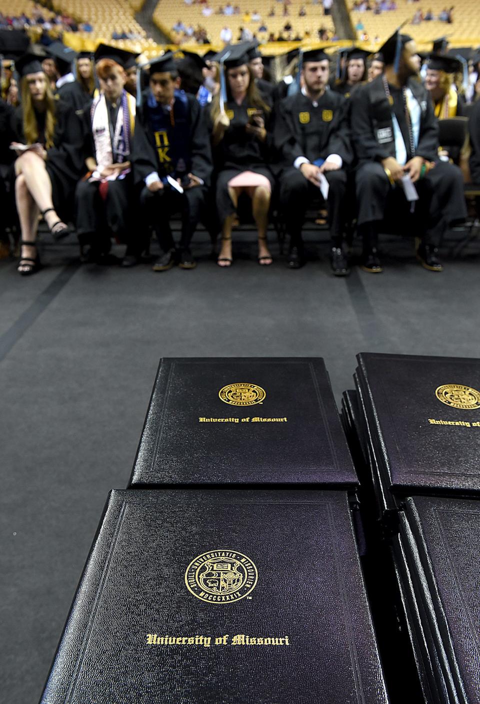 Stacks of diplomas await University of Missouri College of Education and Human Development graduates as they wait for the ceremony to begin on Friday at Mizzou Arena.