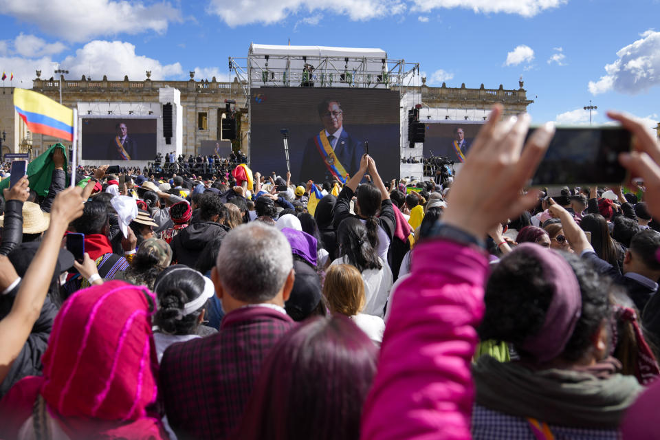 La imagen del nuevo presidente Gustavo Petro con la banda presidencial se muestra en pantallas gigantes después de prestar juramento durante su ceremonia de investidura en la plaza de Bolívar en Bogotá, Colombia, el domingo 7 de agosto de 2022. (AP Foto/Ariana Cubillos)