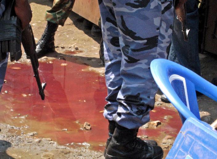 Armed security officers stand around a pool of blood at the scene of an attack by armed raiders on September 19, 2011 in the capital Bujumbura (AFP Photo/Esdras Ndikumana)