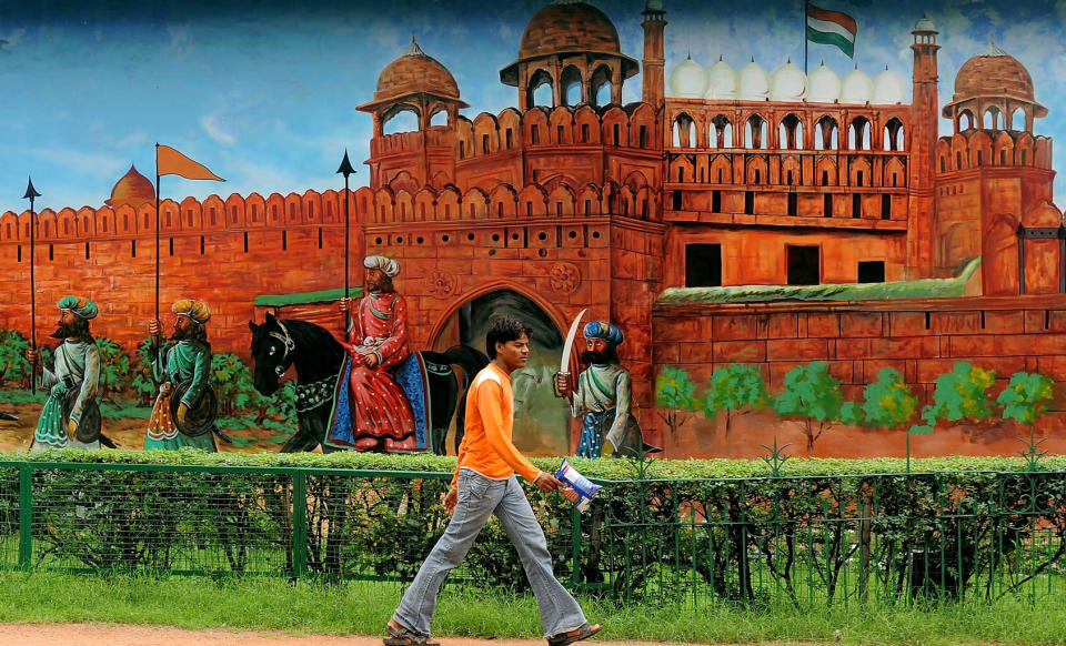 An Indian pedestrian walks past a wall decorated with a mural in New Delhi.<br>AFP PHOTO/MANAN VATSYAYANA