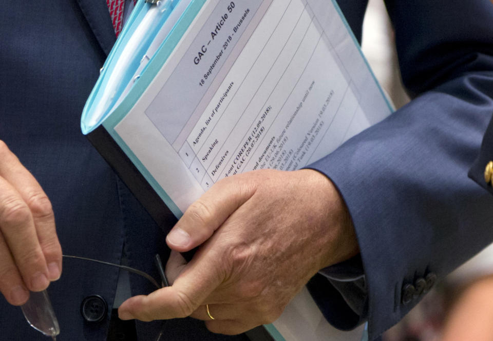 EU chief Brexit negotiator Michel Barnier arrives with his papers for a General Affairs Article 50 Council at the Europa building in Brussels, Tuesday, Sept. 18, 2018. A top European Union official on Tuesday said Britain and the EU could yet fail to reach an agreement on the terms of their divorce, just six months before the U.K. is due to leave the bloc. (AP Photo/Virginia Mayo)