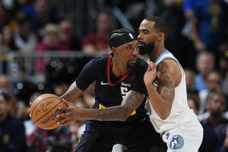 Denver Nuggets guard Kentavious Caldwell-Pope, left, looks to pass the ball as Minnesota Timberwolves guard Mike Conley defends in the second half of Game 7 of an NBA second-round playoff series Sunday, May 19, 2024, in Denver. (AP Photo/David Zalubowski)