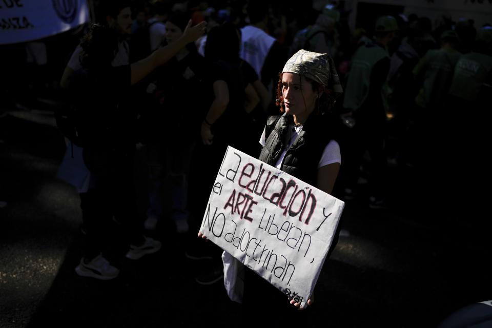 A veterinary student Agustina Aguirre holds a sign that reads in Spanish "Education and art liberate, they do not indoctrinate" during a march demanding more funding for public universities and against austerity measures proposed by President Javier Milei in Buenos Aires, Argentina, Tuesday, April 23, 2024. (AP Photo/Natacha Pisarenko)