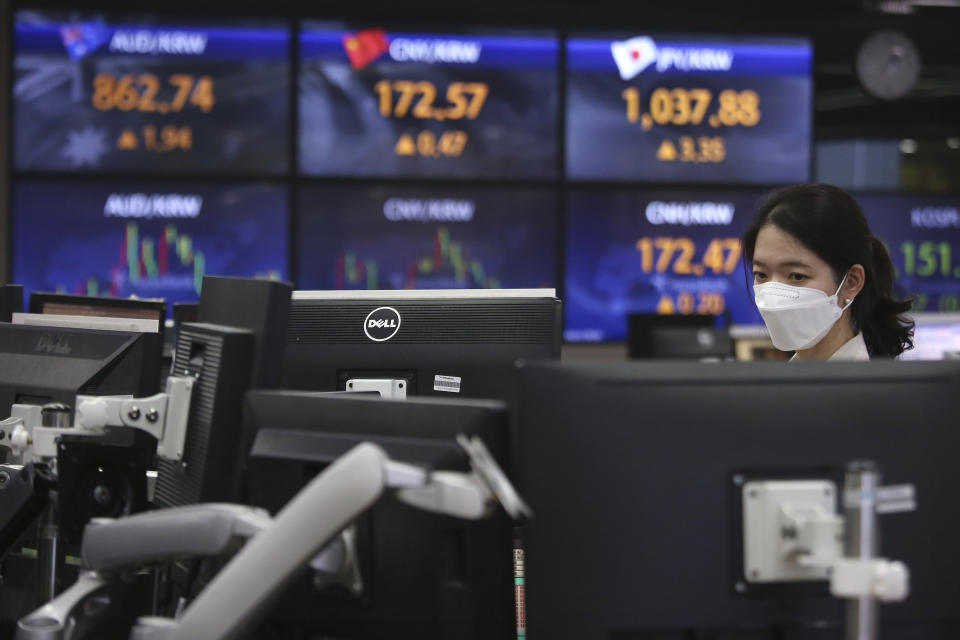 A currency trader watches monitors at the foreign exchange dealing room of the KEB Hana Bank headquarters in Seoul, South Korea, Friday, April 23, 2021. Asian stock markets were mixed Friday after Wall Street fell following a report that President Joe Biden will propose raising taxes on wealthy investors. (AP Photo/Ahn Young-joon)