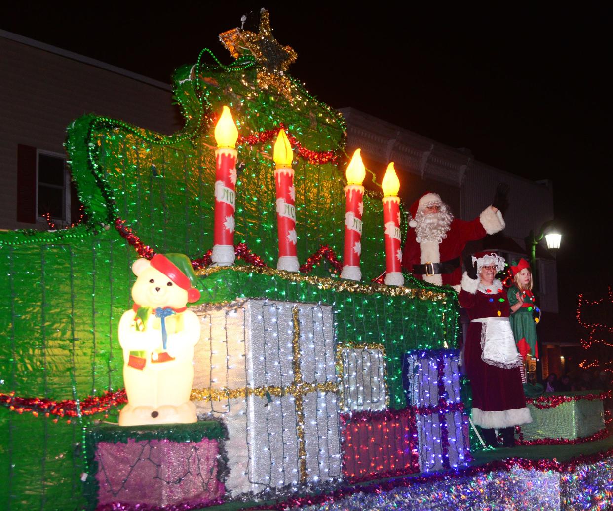 Santa and Mrs. Claus wave to the crowd atop a float loaded with glittery, decorated Christmas gifts during Sebring Village's annual Christmas parade on Saturday, Dec. 2, 2023.