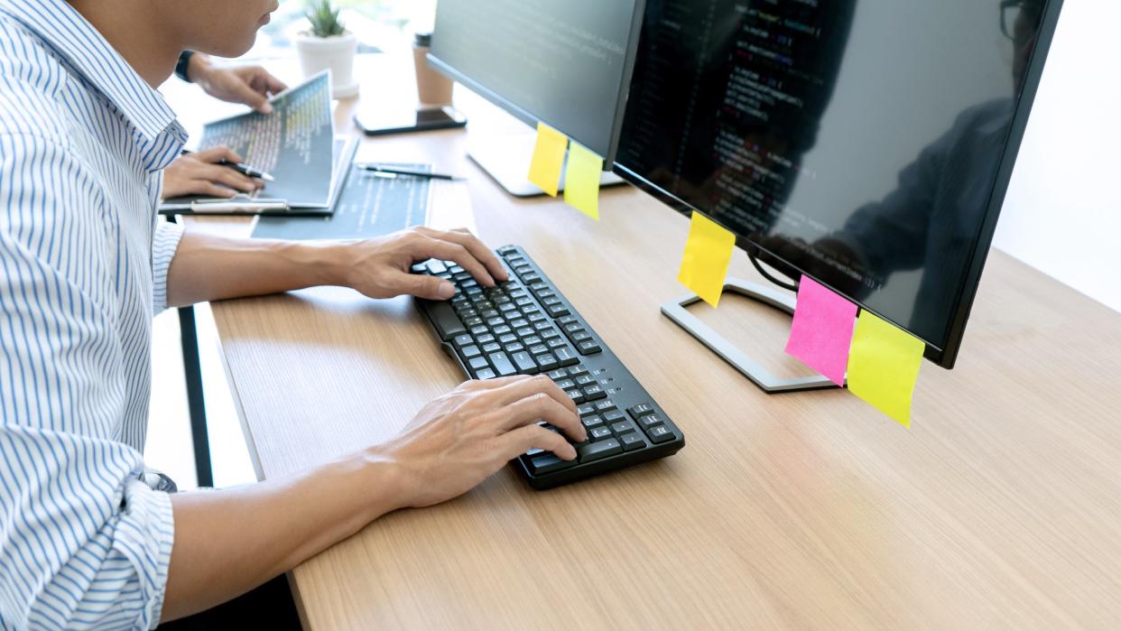 Man at desktop computer entering computer code