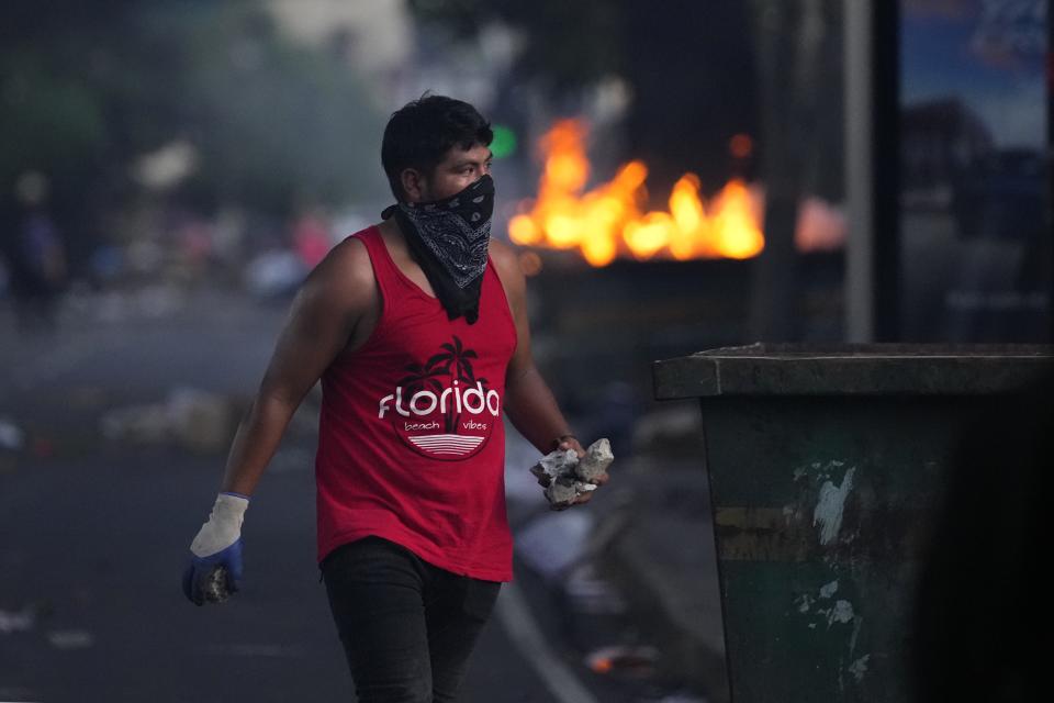 A demonstrator holds rocks during clashes with the police at a protest against a recently approved mining contract between the government and Canadian mining company First Quantum, outside the National Assembly in Panama City, Monday, Oct. 23, 2023. (AP Photo/Arnulfo Franco)