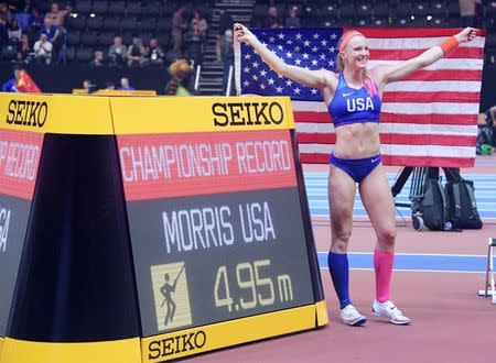 Mar 3, 2018; Birmingham, United Kingdom; Sandi Morris (USA) poses with United States flag and scoreboard after winning the women's pole vault in a championship record 16-2 3/4 (4.95m) during the IAAF World Indoor Championships at Arena Birmingham. Mandatory Credit: Kirby Lee-USA TODAY Sports