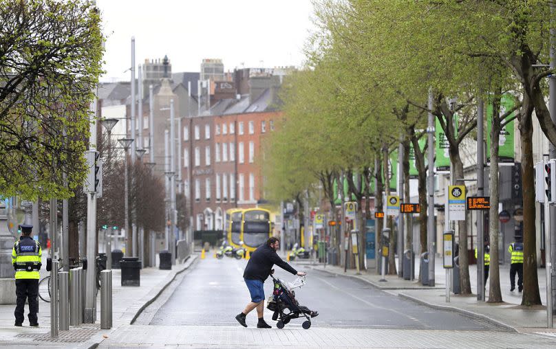 A man pushes a buggy in downtown Dublin, 12 April 2020