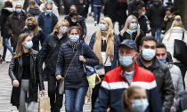 People wear mandatory face masks due to the coronavirus pandemic in a shopping street in the high risk zone Gelsenkirchen, Germany, Tuesday, Oct. 20, 2020. Germany's most populated area, the entire Ruhr valley, exceeded the important warning level of 50 new infections per 100,000 inhabitants in seven days. The city in the center of the Ruhr ordered to wear masks in many public streets. (AP Photo/Martin Meissner)