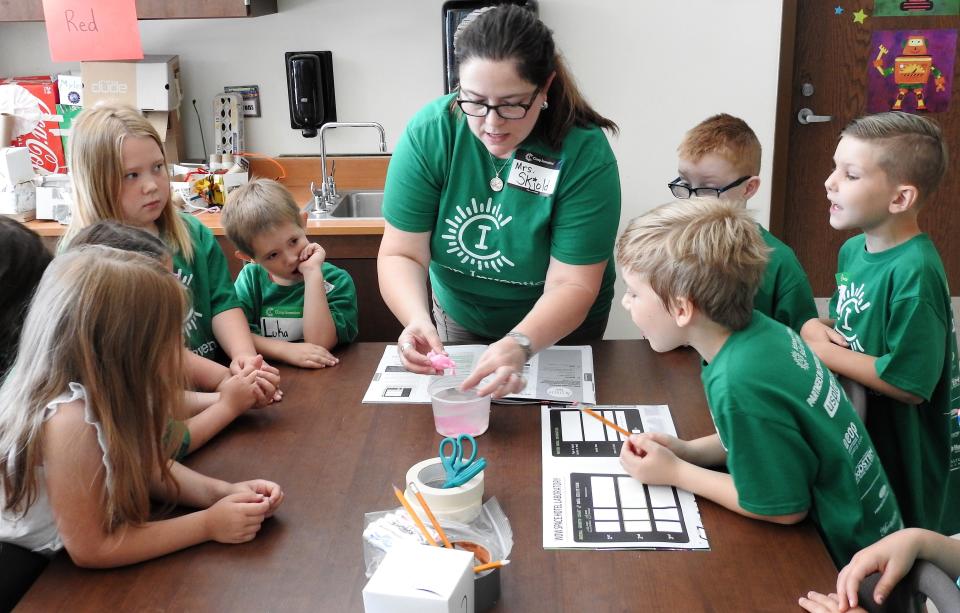 Laura Skjold shows youth a flamingo that grew in water during an experiment as part of Camp Invention at Coshocton Elementary School. The program expanded to all three school districts in Coshocton County last year and served about 225 youth.