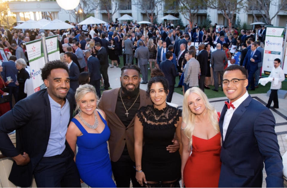 Savannah Foster (L), pictured with clients Landon Collins (M) of the Washington Redskins and Noah Fant (R) of the Denver Broncos at a company charity event, is an agent at Athletes First.