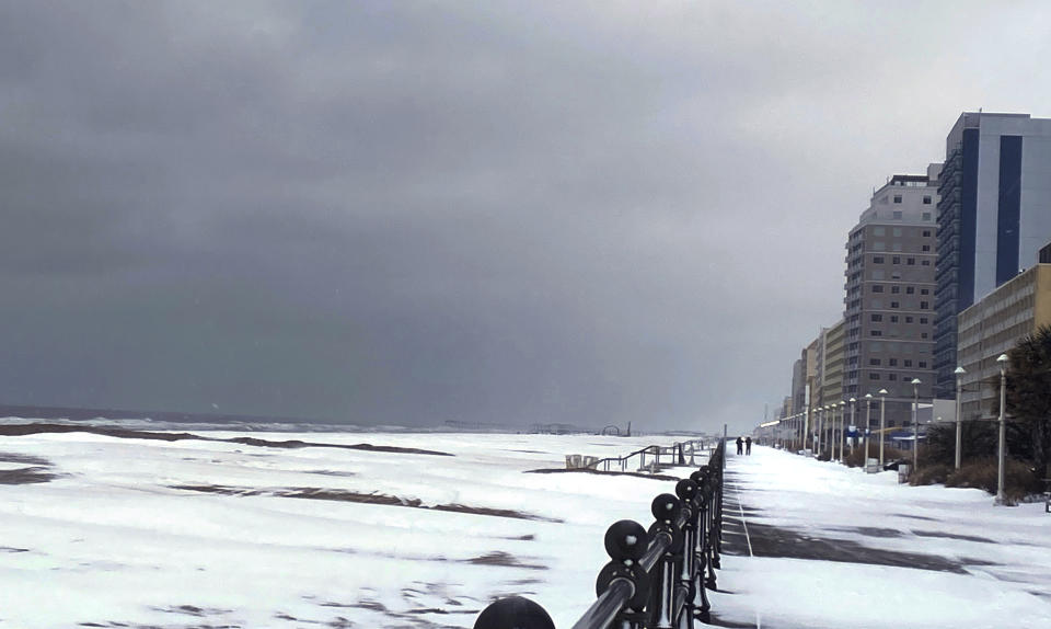 Snow covers the Virginia Beach oceanfront, Saturday, Jan. 22, 2022 in Virginia Beach, Va. A layer of ice and a blanket of snow has covered coastal areas stretching from South Carolina to Virginia. The winter weather system that entered the region on Friday brought colder temperatures and precipitation not often seen in the region. (Stacy Parker/The Virginian-Pilot via AP)