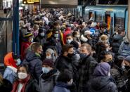 FILE - People with face masks stand close together as they wait for a subway train in Frankfurt, Germany, Wednesday, Dec. 2, 2020. Germany is set to mark 100,000 deaths from COVID-19 this week, passing a somber milestone that several of its neighbors crossed months ago but which some in Western Europe's most populous nation had hoped to avoid. (AP Photo/Michael Probst)